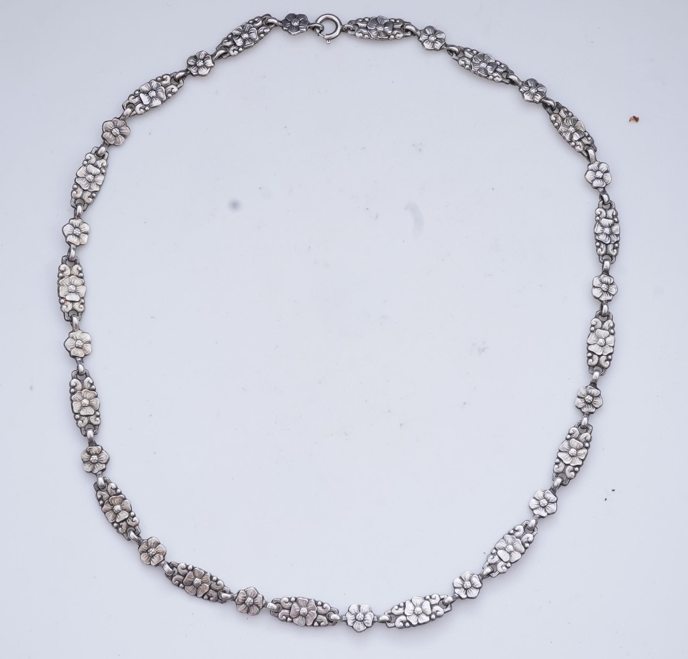 A collection of three silver chains and an Art Nouveau brooch, early 20th century